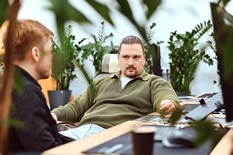 Участники команды KT.Team разговаривают в зелёном офисе